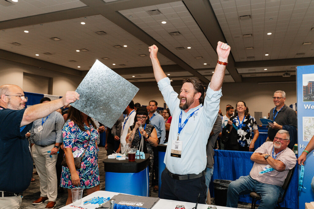 Attendee receiving a raffle prize during a trade show floor reception, highlighting attendee engagement and event activation