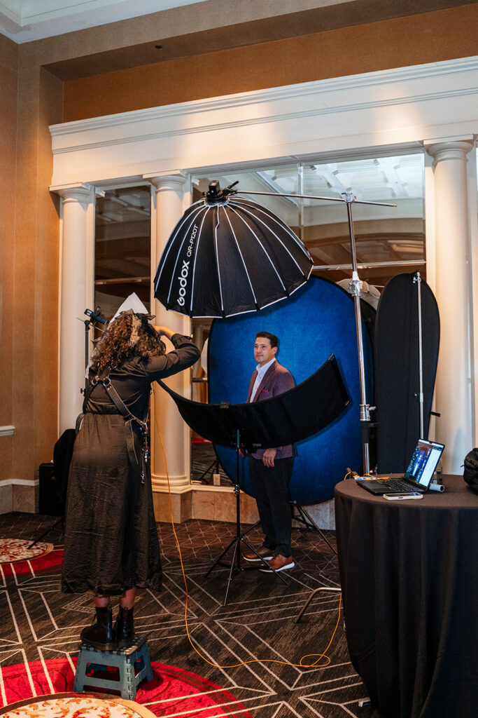 True Colors Creative photographer capturing a professional headshot for an attendee at an on-site headshot station during a corporate event.