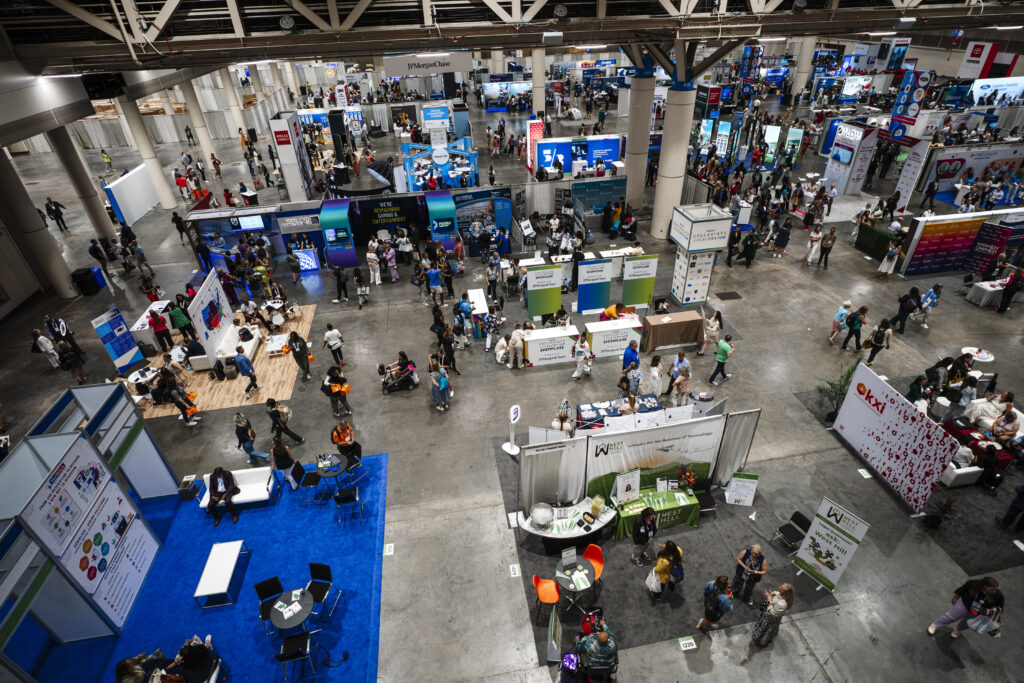 Attendees walking through a busy trade show floor with exhibits in Las Vegas Convention Center