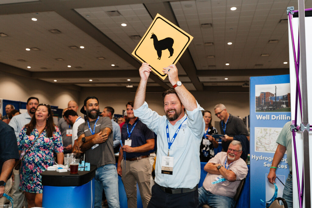 Association event photography captures members gathering during a networking happy hour in the exhibit hall, capturing candid engagement and connection at a professional conference.