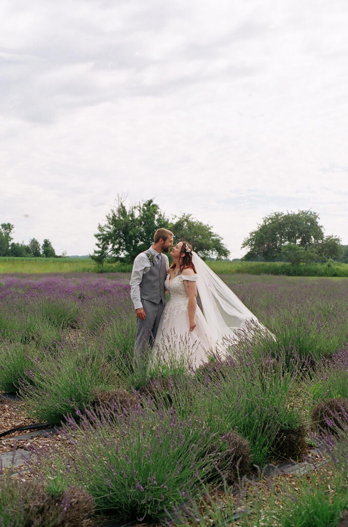 Bride and groom share an intimate moment surrounded by blooming lavender fields captured on film by a destination wedding photographer available across the West Coast and Southwest