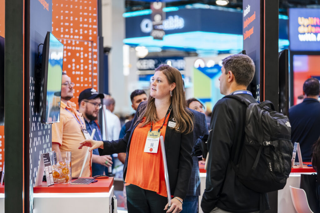 Exhibit photography captures a sales pitch and product demonstration to an attendee in a booth at a Las Vegas trade show.