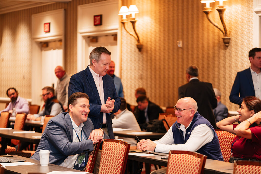 Association event photography captures leaders and members connecting in conversation during a conference session, reflecting professional networking and relationship building.