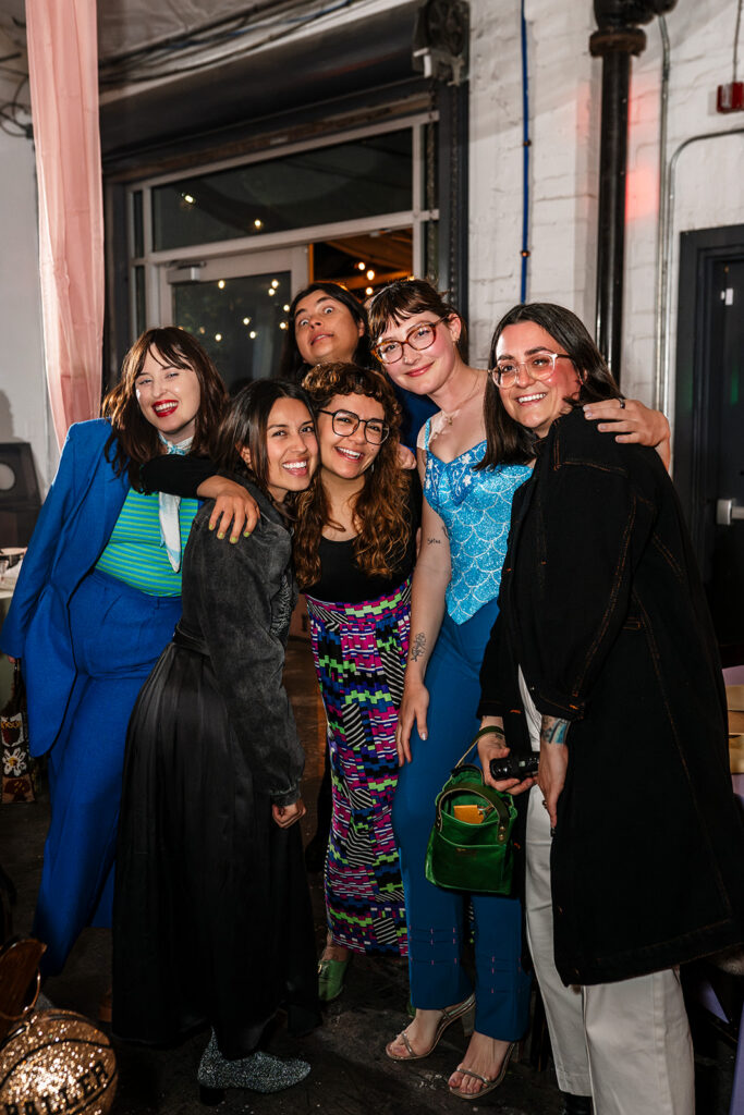 Group of wedding guests laughing together during a high energy large scale wedding reception photographed by True Colors Team Las Vegas wedding photographers