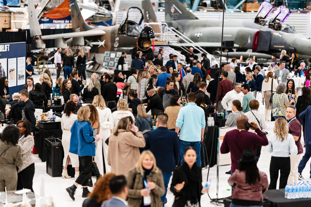 Large gathering of attendees at off-site networking reception.