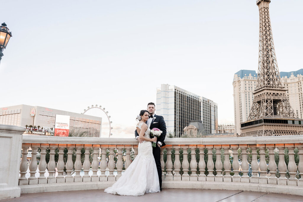 Bride and groom overlooking Las Vegas Strip near Paris Hotel Eiffel Tower replica.