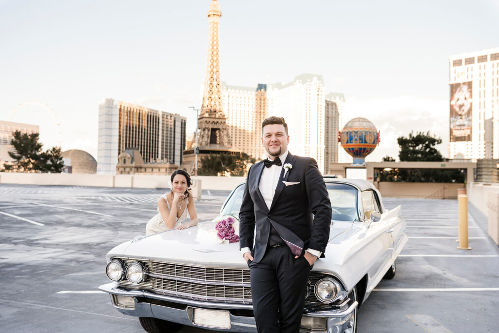 Elopement photographer creating stylish rooftop wedding portrait with vintage car and Las Vegas Strip skyline at sunset.